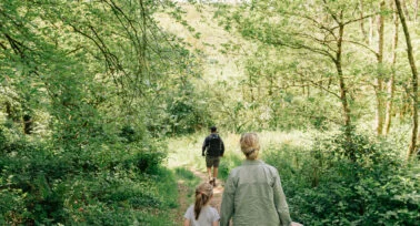 family walking through woodland at yeatheridge