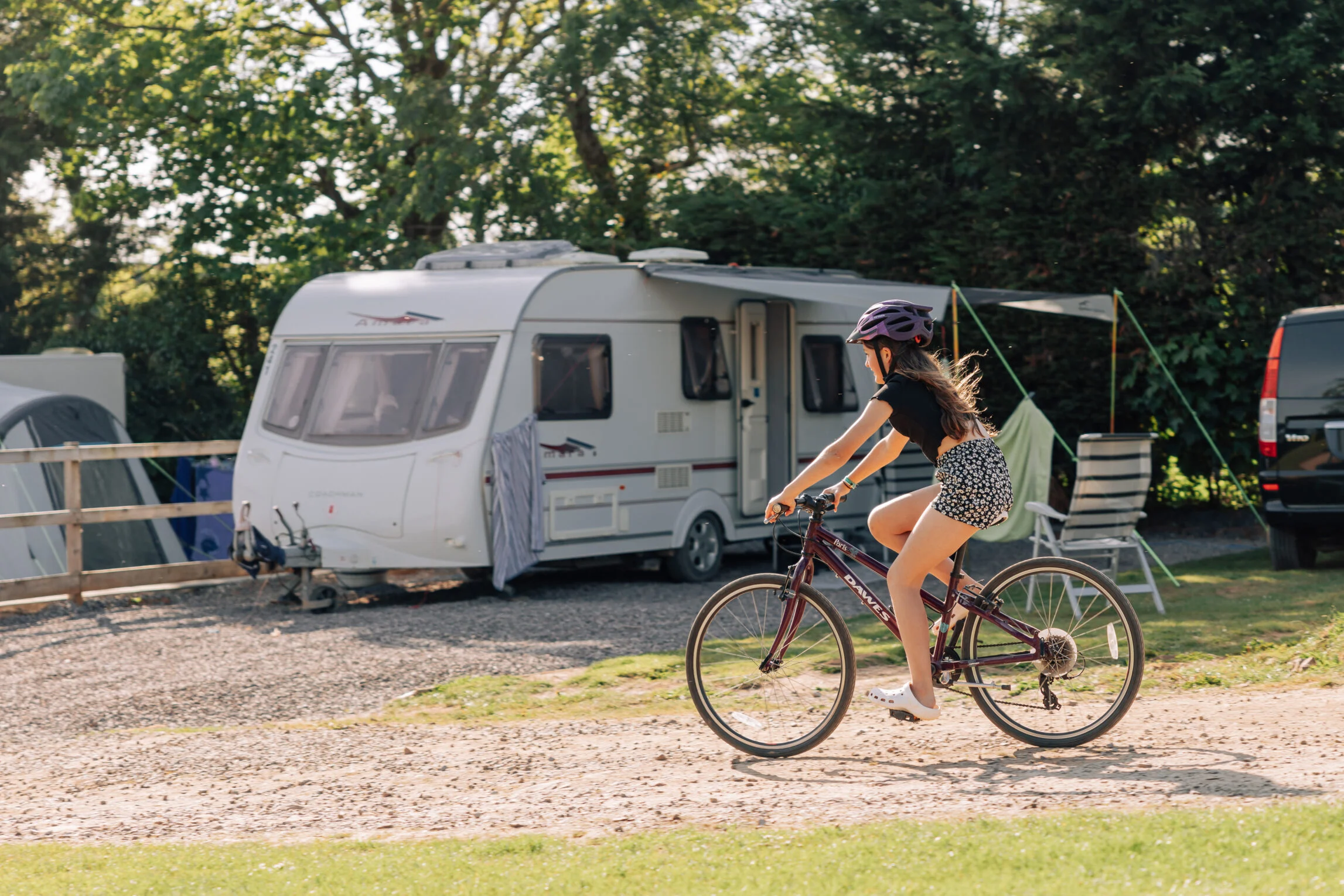girl cycling past touring caravan at Yeatheridge